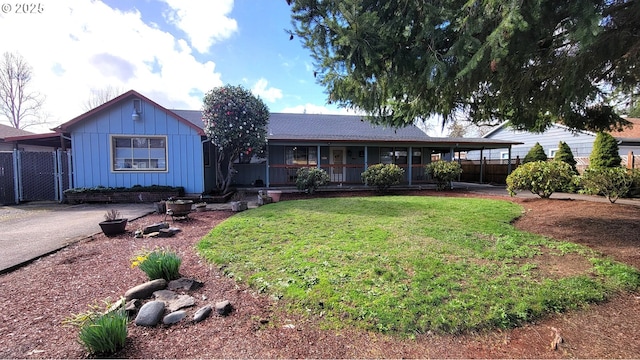 ranch-style home featuring board and batten siding, a front yard, covered porch, and fence