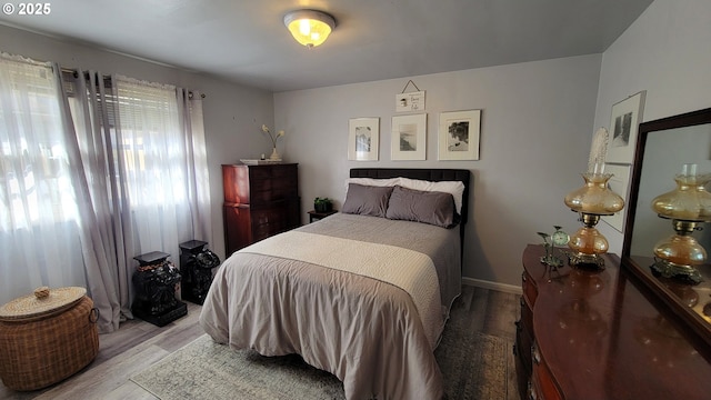 bedroom with light wood-style flooring and baseboards