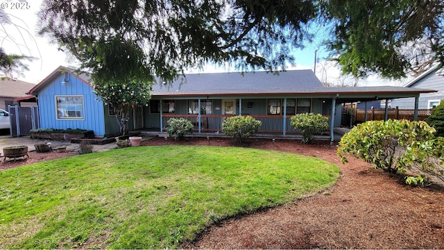 back of property with a yard, a porch, and fence