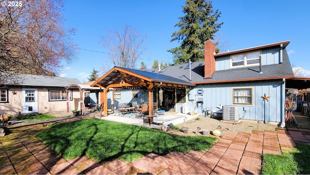 rear view of property with cooling unit, a chimney, a lawn, and board and batten siding