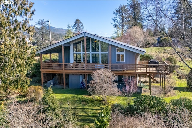 rear view of property with a lawn and a deck