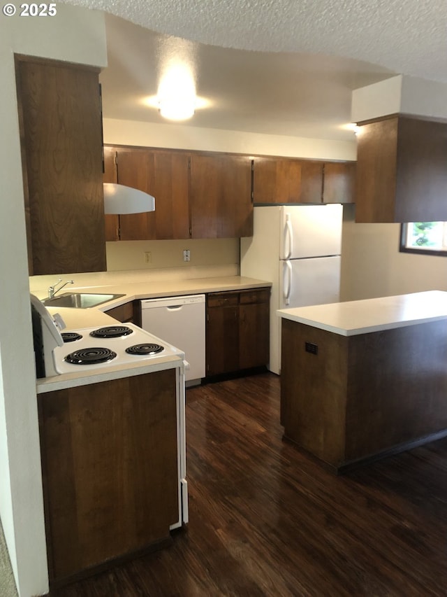 323 S Locust St, Canby, OR 97013 - kitchen featuring white appliances, dark wood-style flooring, light countertops, a textured ceiling, and a peninsula