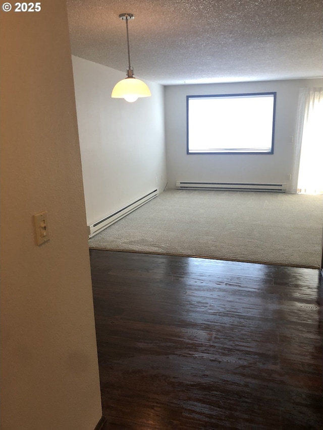 323 S Locust St, Canby, OR 97013 - spare room featuring baseboard heating, a textured ceiling, and wood finished floors