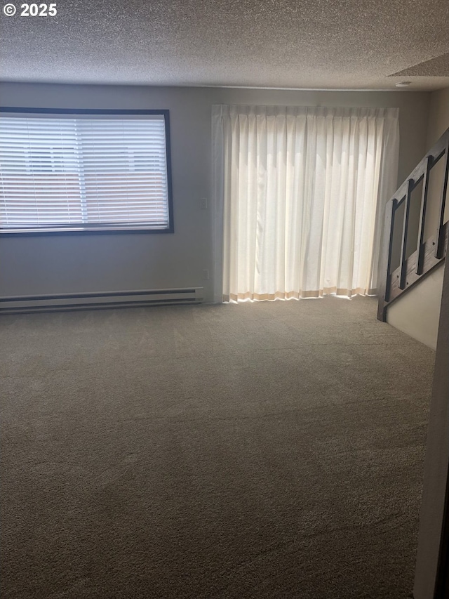 323 S Locust St, Canby, OR 97013 - unfurnished room featuring baseboard heating, a textured ceiling, carpet, and plenty of natural light