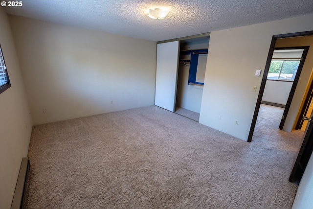 323 S Locust St, Canby, OR 97013 - unfurnished bedroom featuring a baseboard heating unit, carpet, a closet, and a textured ceiling