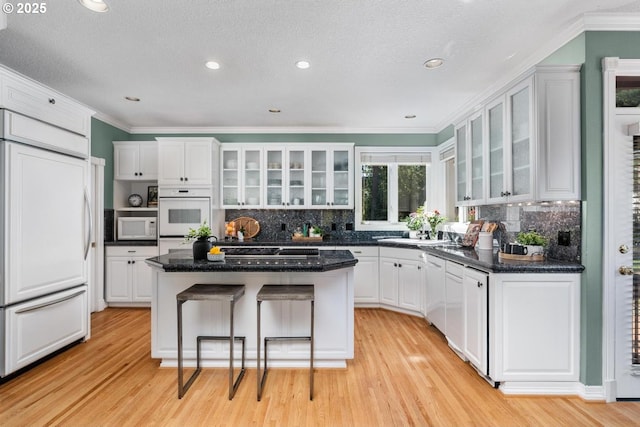 kitchen featuring white cabinets, white appliances, and a center island