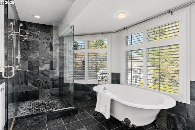 full bathroom with a shower stall, a soaking tub, and a textured ceiling