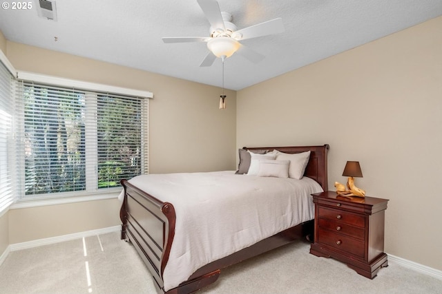 bedroom with light carpet, a ceiling fan, and baseboards