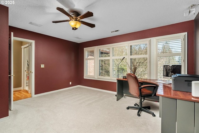 office with a wealth of natural light, carpet floors, a textured ceiling, and a ceiling fan
