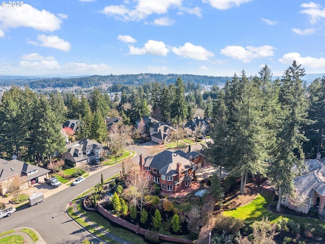 birds eye view of property featuring a wooded view and a residential view