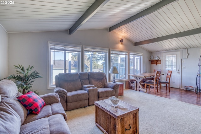 living area featuring vaulted ceiling with beams and light colored carpet