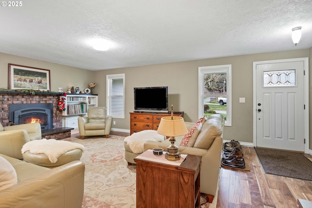 5583 54th Ct, Salem, OR 97317 - living area featuring a textured ceiling, wood finished floors, a fireplace, and baseboards