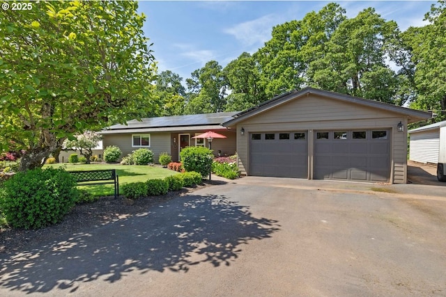5583 54th Ct, Salem, OR 97317 - ranch-style home with solar panels, asphalt driveway, a front yard, and an attached garage