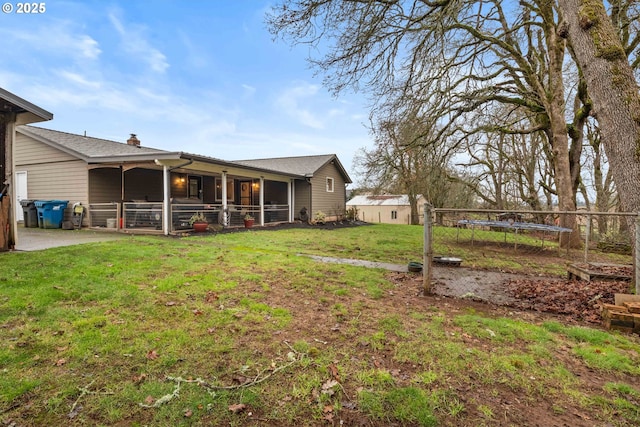 view of yard featuring an outdoor structure and a trampoline