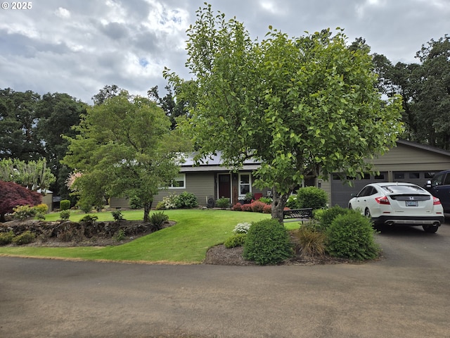 view of front of property featuring a garage and a front lawn