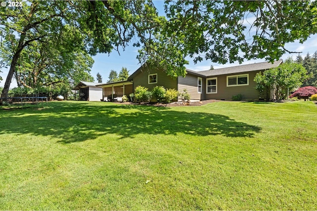 5583 54th Ct, Salem, OR 97317 - rear view of house featuring a trampoline, a lawn, and a sunroom