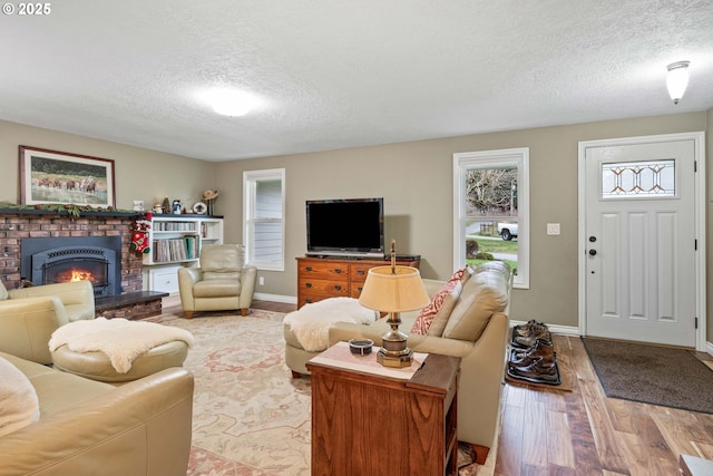 living room featuring hardwood / wood-style flooring, a fireplace, and a textured ceiling