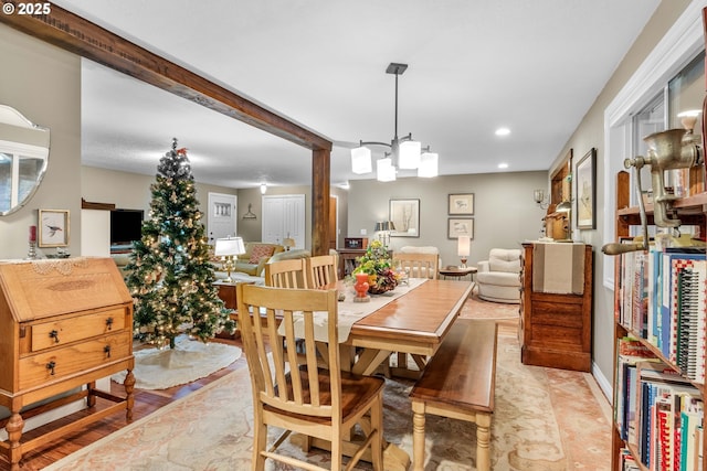 dining area with beamed ceiling and an inviting chandelier