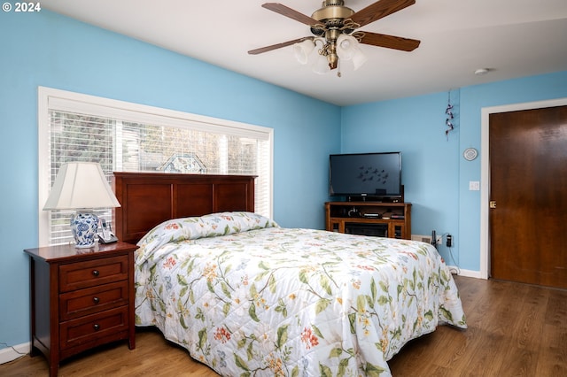 bedroom featuring ceiling fan, wood finished floors, and baseboards