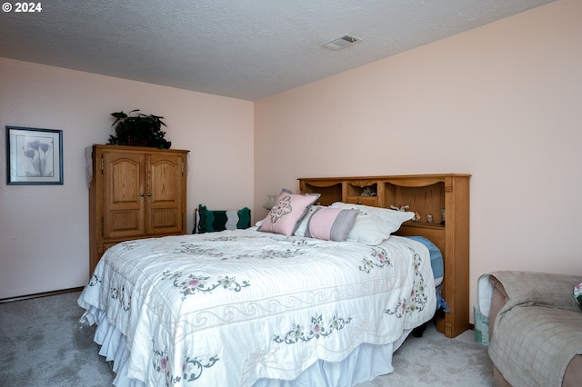 bedroom featuring carpet, visible vents, and a textured ceiling