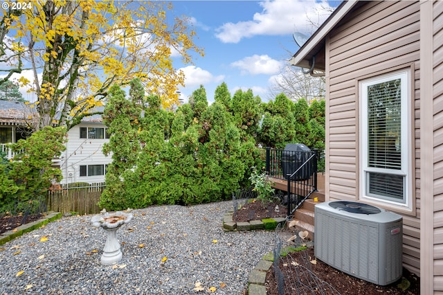 view of yard with cooling unit, a wooden deck, and fence