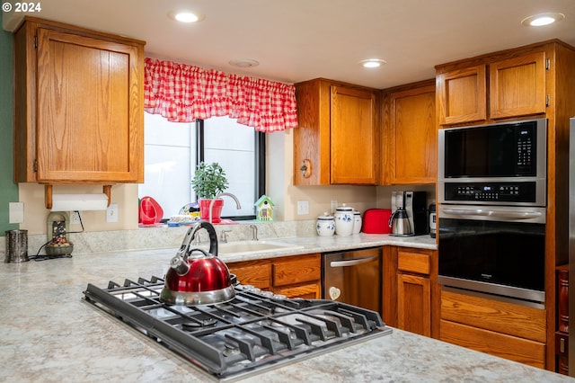 kitchen featuring light countertops, appliances with stainless steel finishes, recessed lighting, and brown cabinets