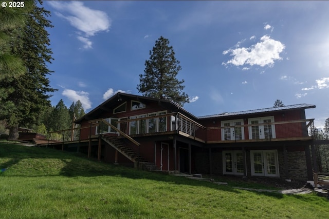 rear view of house with french doors, a wooden deck, stairway, a yard, and metal roof