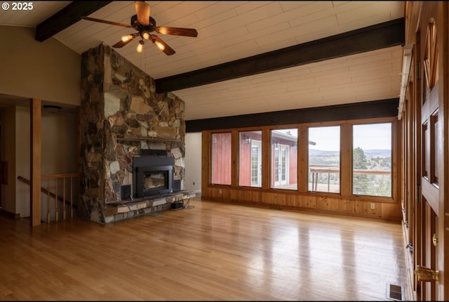 unfurnished living room featuring wood finished floors, ceiling fan, and a stone fireplace