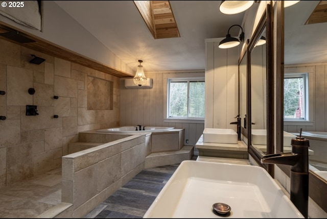 bathroom featuring healthy amount of natural light, a bath, and tiled shower