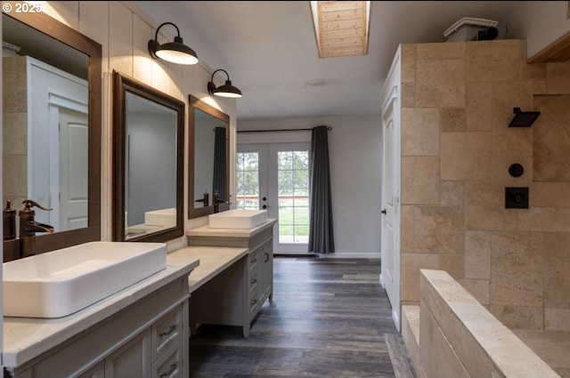bathroom featuring tiled shower, vanity, wood finished floors, and french doors