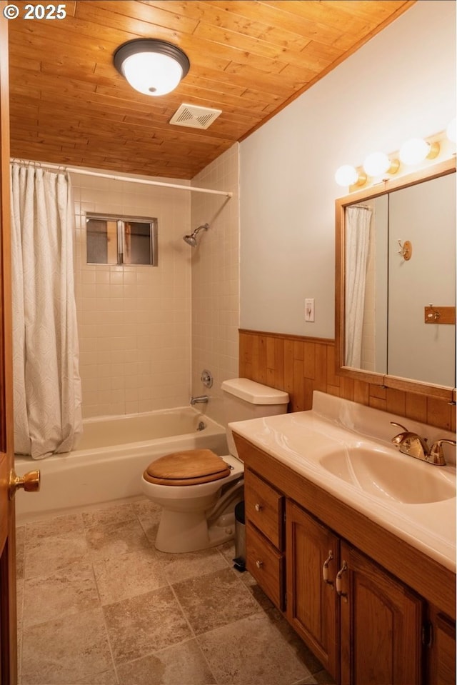 bathroom with wood ceiling, a wainscoted wall, shower / bath combo with shower curtain, toilet, and wooden walls