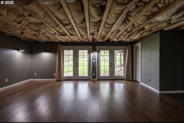 spare room featuring baseboards, wood finished floors, and french doors