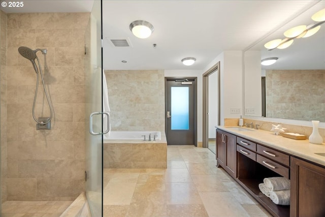 bathroom featuring vanity and shower with separate bathtub