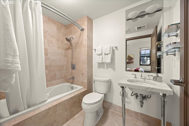 bathroom with toilet, tile patterned flooring, and shower / bath combo with shower curtain