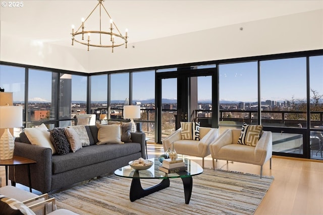 living room with a healthy amount of sunlight, a chandelier, and light hardwood / wood-style flooring