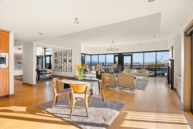 dining area featuring an inviting chandelier and light hardwood / wood-style flooring