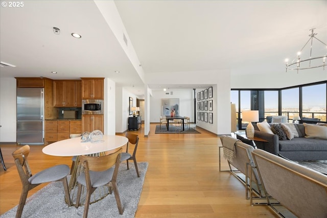 dining room with light hardwood / wood-style flooring and a notable chandelier