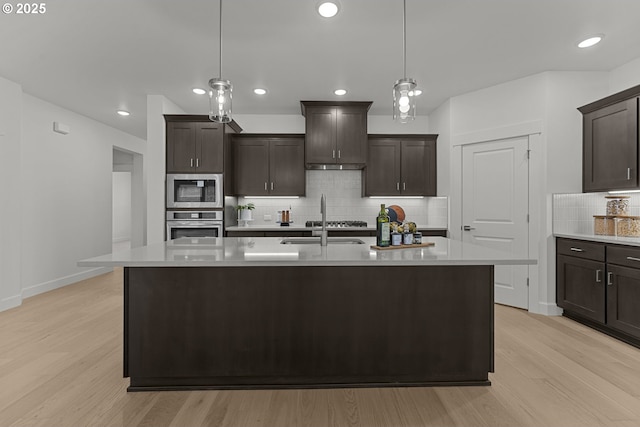 15129 SW Huntwood St, Tigard, OR 97224 - kitchen featuring appliances with stainless steel finishes, a sink, light wood finished floors, light countertops, and backsplash