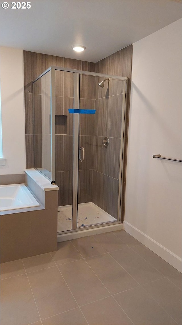 bathroom with tile patterned floors, a garden tub, and a stall shower