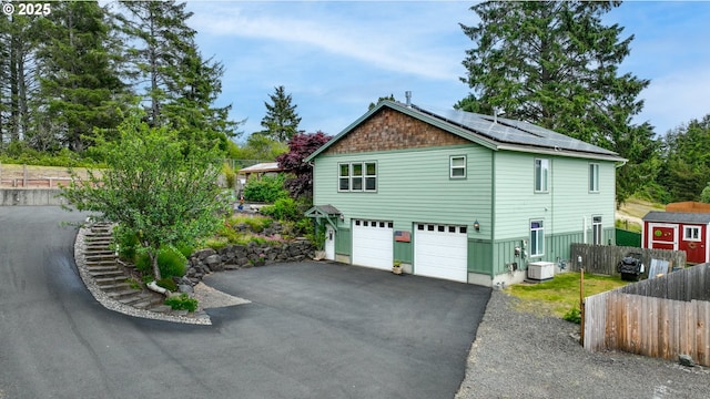 1395 Dooley Ln, Gearhart, OR 97138 - view of side of property with solar panels, a garage, and asphalt driveway