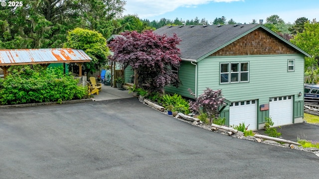 1395 Dooley Ln, Gearhart, OR 97138 - view of front facade with asphalt driveway, a garage, and roof with shingles