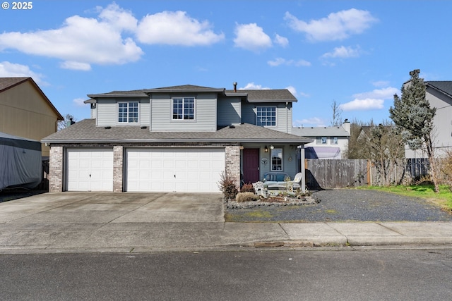 traditional-style house featuring a shingled roof, driveway, an attached garage, and fence