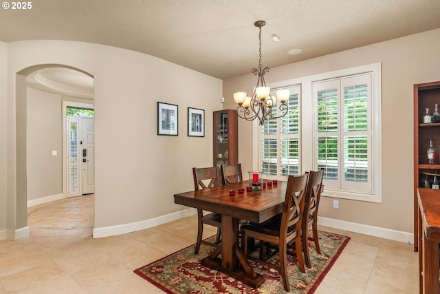 8967 SW 184th Dr, Beaverton, OR 97007 - dining space with plenty of natural light, a chandelier, arched walkways, and light tile patterned floors