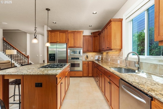 8967 SW 184th Dr, Beaverton, OR 97007 - kitchen with stainless steel appliances, brown cabinets, decorative backsplash, light stone countertops, and recessed lighting