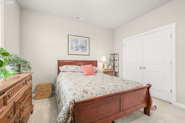 bedroom with light carpet and a closet