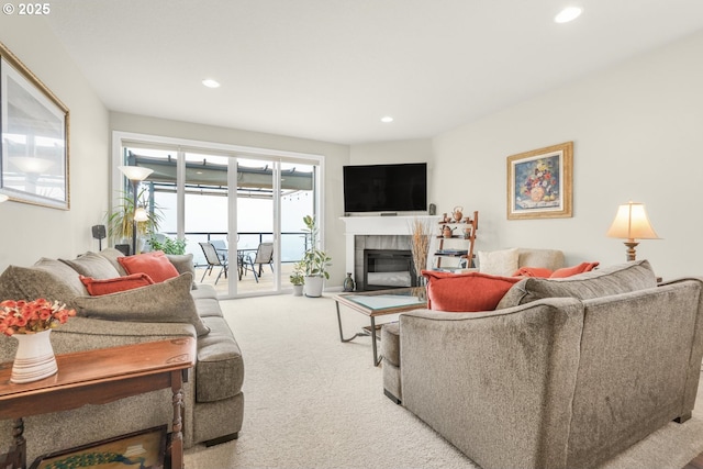 carpeted living room featuring a tile fireplace