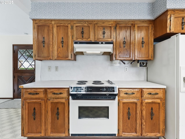 kitchen featuring brown cabinetry, light countertops, under cabinet range hood, and white appliances