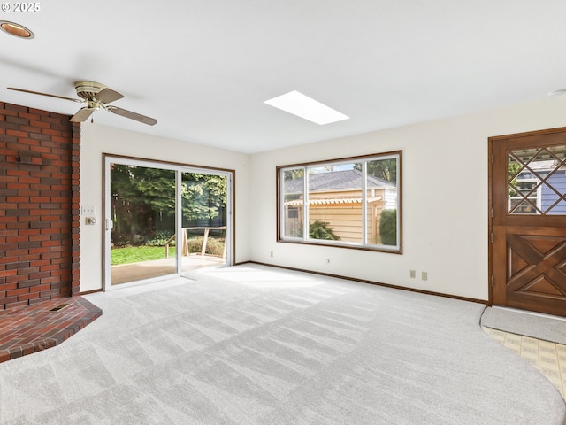 unfurnished living room featuring plenty of natural light, carpet flooring, and a skylight