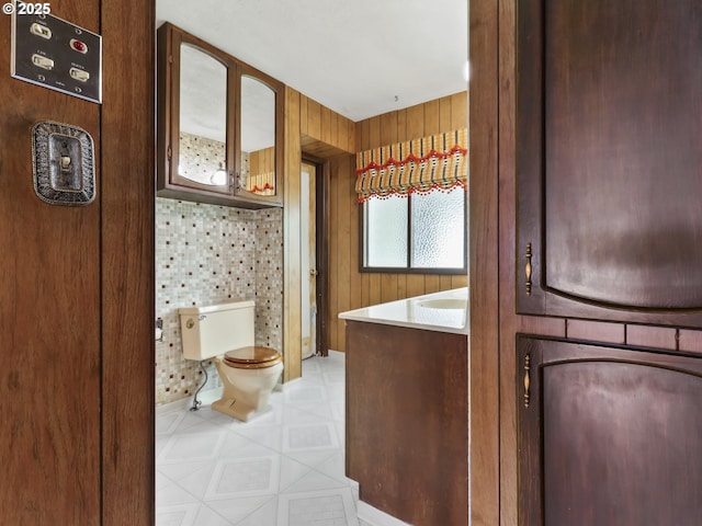 bathroom with wooden walls and toilet
