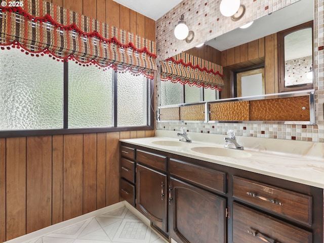 bathroom with a sink, wooden walls, and double vanity